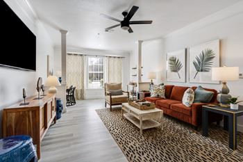 a living room with a red couch and a ceiling fan
